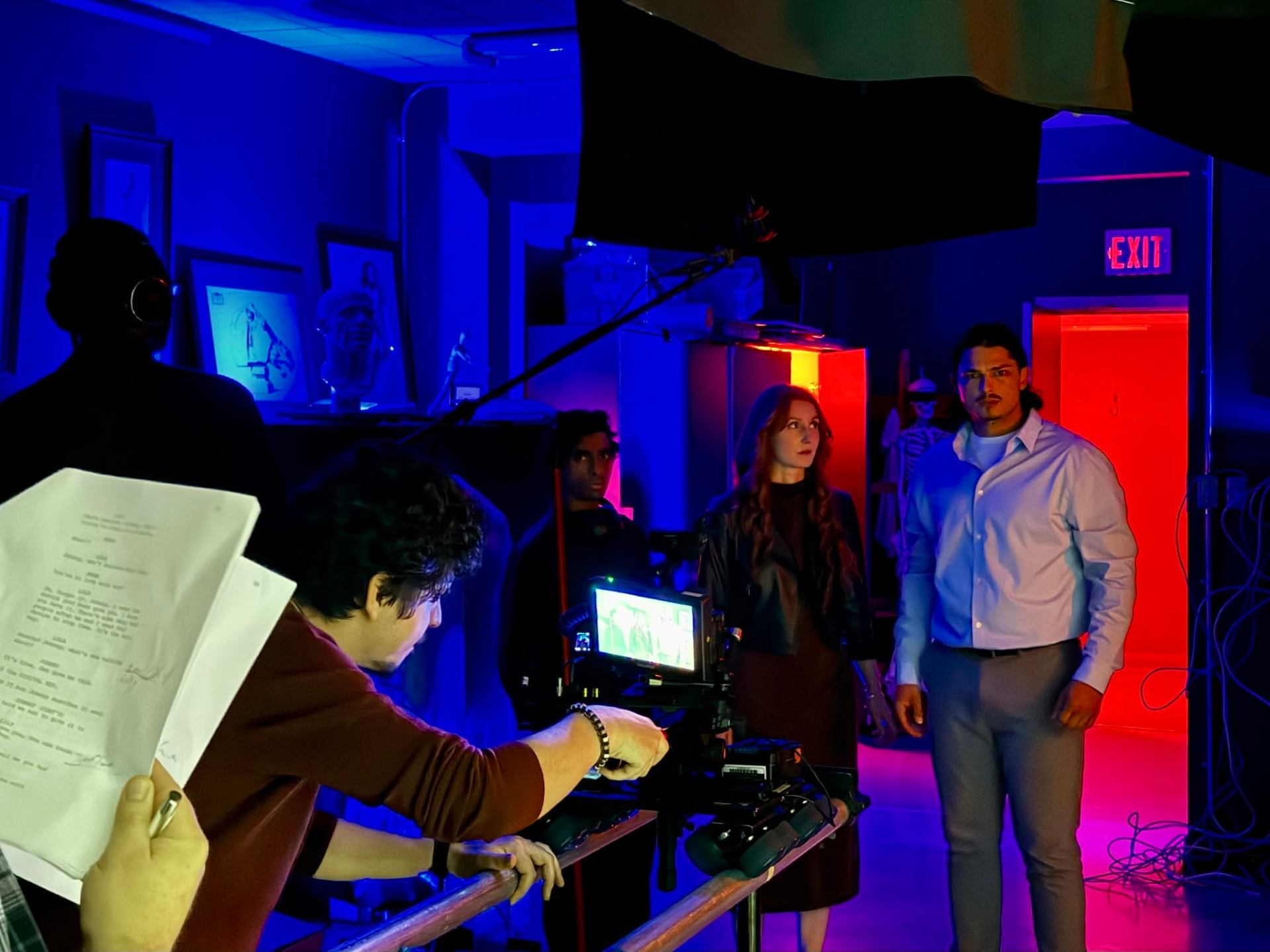 Andres directing a narrative scene with cast under red and blue lighting